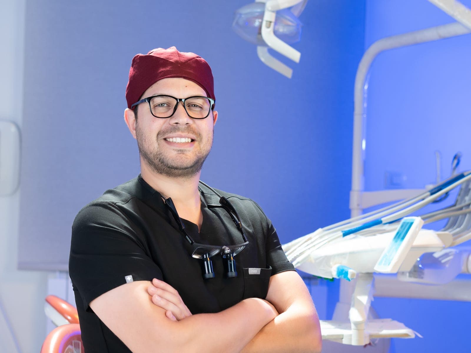 Un chirurgien-dentiste dans une salle de soin de la clinique, bras croisés
